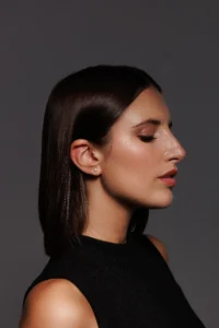 Primo piano della modella che indossa Orecchini Punto Luce in Argento 925 placcato oro giallo con brillante bianco, un gioiello luminoso e raffinato.