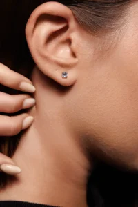 Primo piano di una modella con gli Orecchini Punto Luce in Argento 925 con brillanti bianchi, evidenziando la brillantezza e il design minimal.
