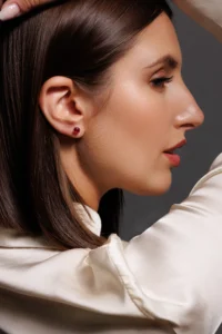 Modella che indossa Orecchini Punto Luce con brillanti fucsia, un gioiello luminoso e dal design elegante.