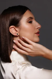 Modella che sfoggia Orecchini Punto Luce con brillanti verdi, un design elegante e sofisticato.