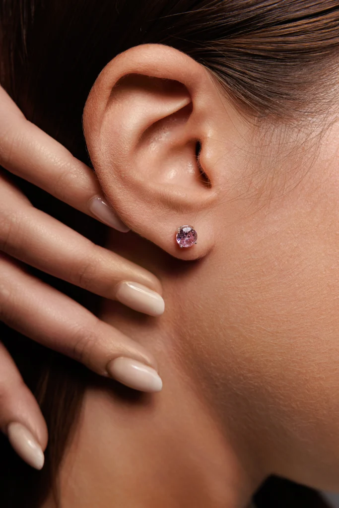 Primo piano di una modella con gli Orecchini Punto Luce con brillanti rosa in Argento 925, enfatizzando la brillantezza e il design.