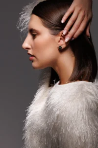 Primo piano della modella che indossa l'Orecchino Round Cuore in Argento 925 con smalto nero, perfetto per un tocco elegante e versatile.