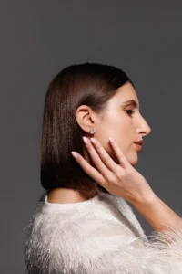 Modella che indossa l'orecchino Round Margherita Bianco, visibile al lobo.