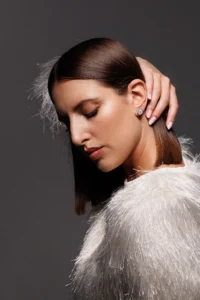 Modella che indossa l'orecchino Round Fiocco Bianco, visibile al lobo.