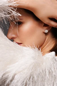 Primo piano del viso di una modella con l'orecchino Round Fiocco Bianco.