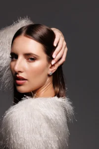 Modella che indossa l'orecchino Round Dalia Bianco, visibile al lobo.