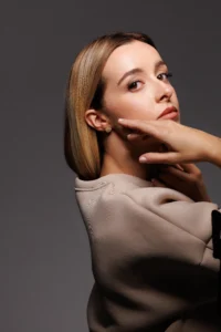 Modella che indossa l'orecchino Round Margherita Bianco, visibile al lobo.