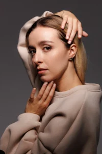 Modella che indossa l'orecchino Round Cuore Bianco, visibile al lobo.