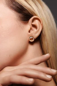 Primo piano del viso di una modella con l'orecchino Round Cuore Bianco.