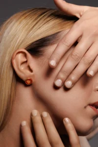 Modella che indossa l'orecchino Round Cuore Rosso, visibile al lobo.