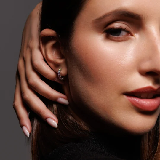 Close-up dell’orecchio della modella con Orecchini a Cerchio in Argento 925 e brillanti multicolor, un gioiello originale e luminoso.