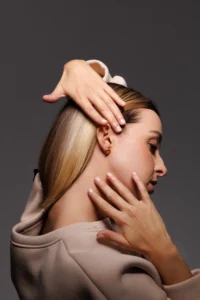 Modella che indossa l'orecchino Round Dalia Nero, visibile al lobo.