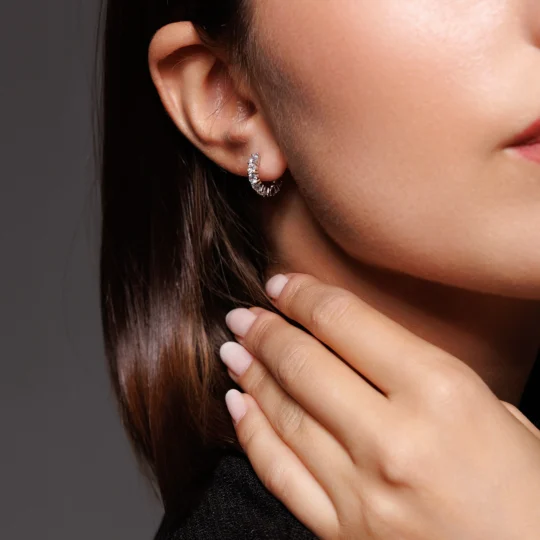 Primo piano della modella che indossa Orecchini a Cerchio in Argento 925 con brillanti bianchi, perfetti per un’eleganza senza tempo.