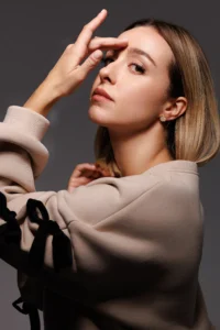 Modella che indossa l'orecchino Round Fiocco Bianco Placcato Oro.