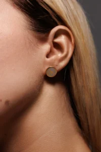 Primo piano del viso di una modella con l'orecchino Round Fiocco Bianco Placcato Oro.